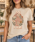 As I Am botanical fingerprint warm sand boutique tee modeled by a woman