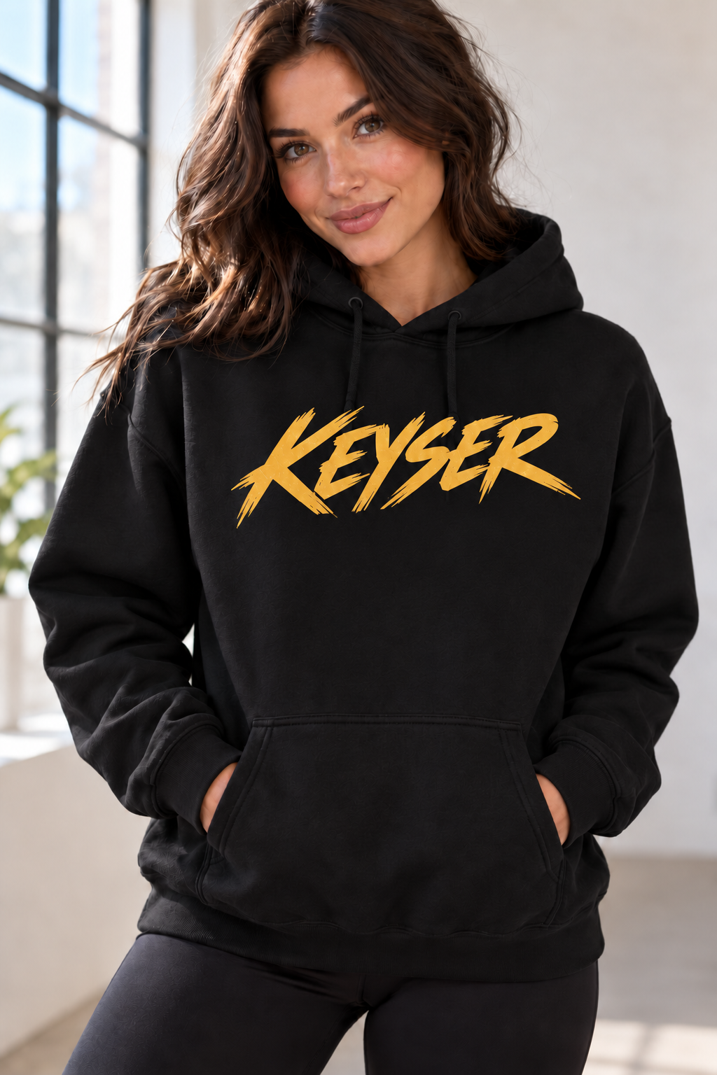 Black Keyser hoodie with gold brush lettering on model