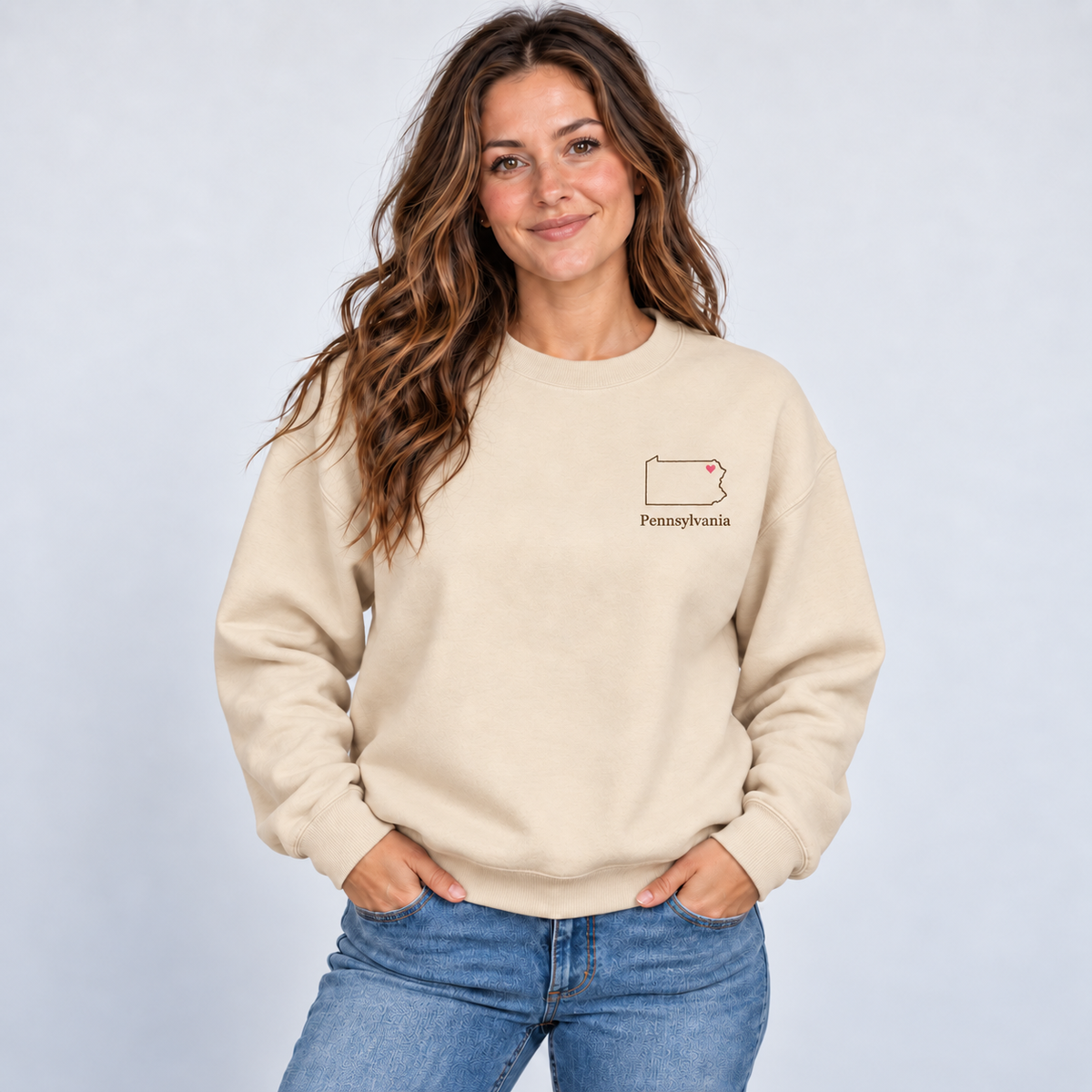 Pennsylvania minimal hometown outline and pink heart on a Gildan G180 Sand crewneck